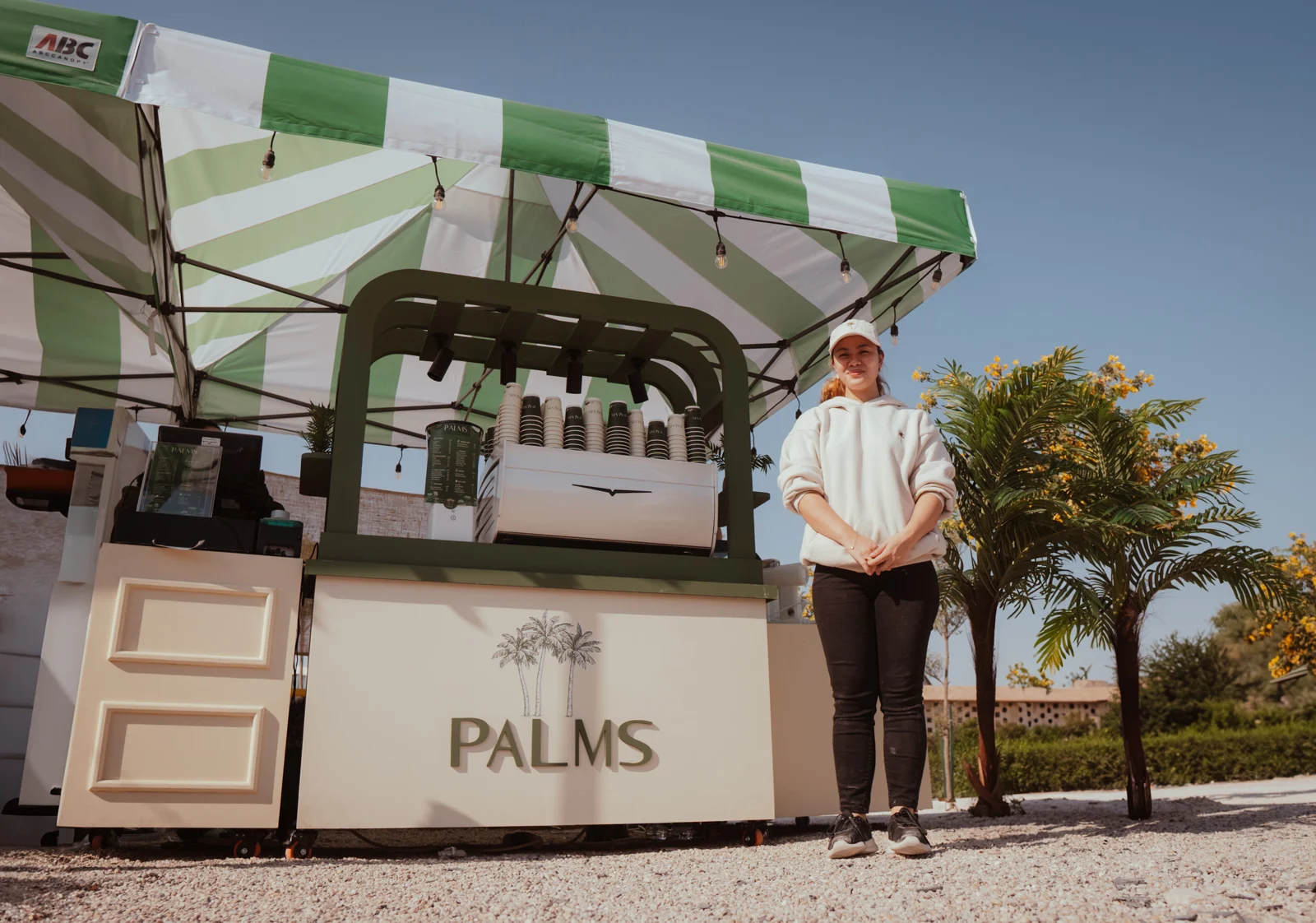 PALMS café kiosk and its green striped canopy