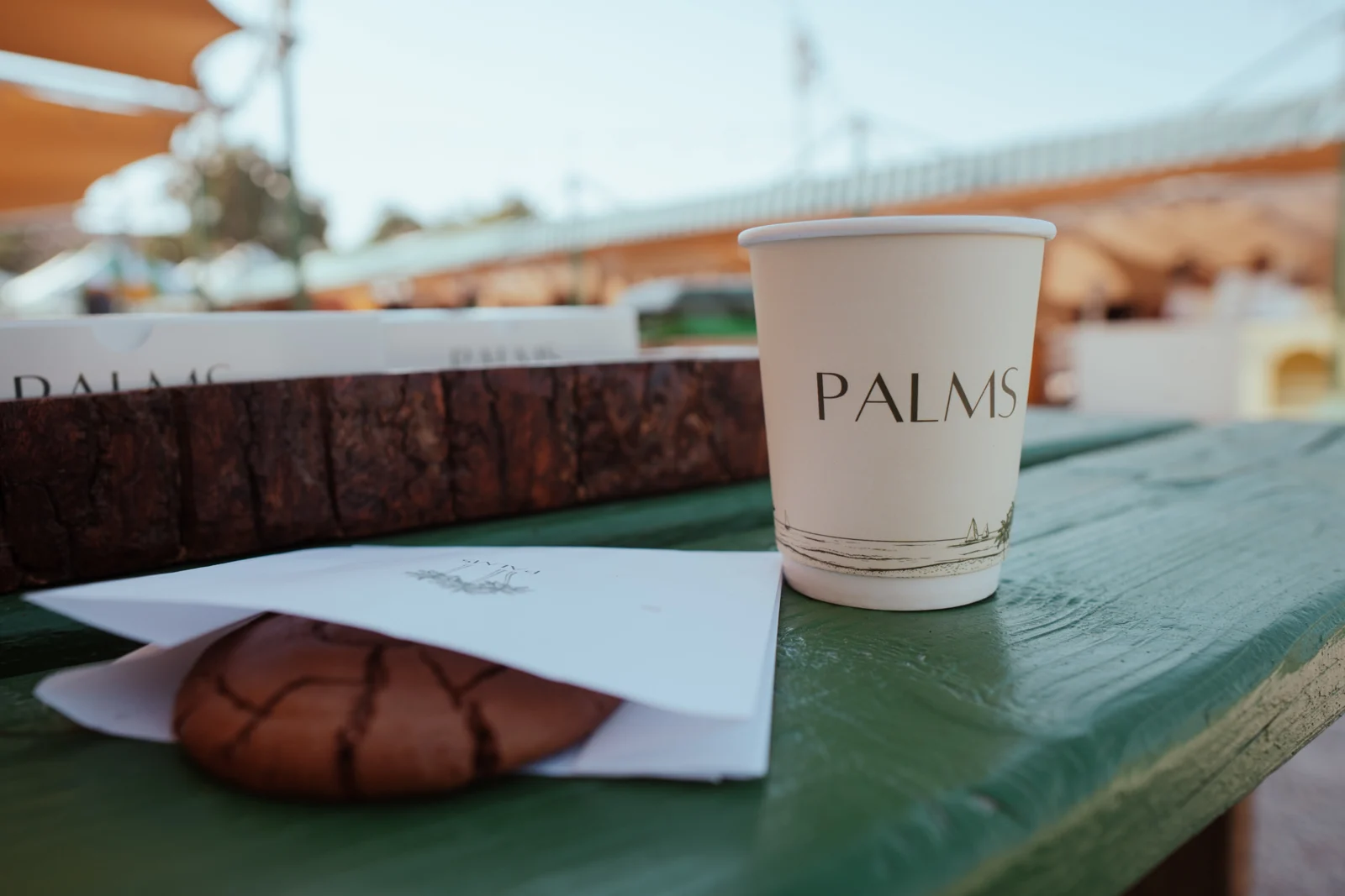 PALMS coffee cup and croissant on a café table