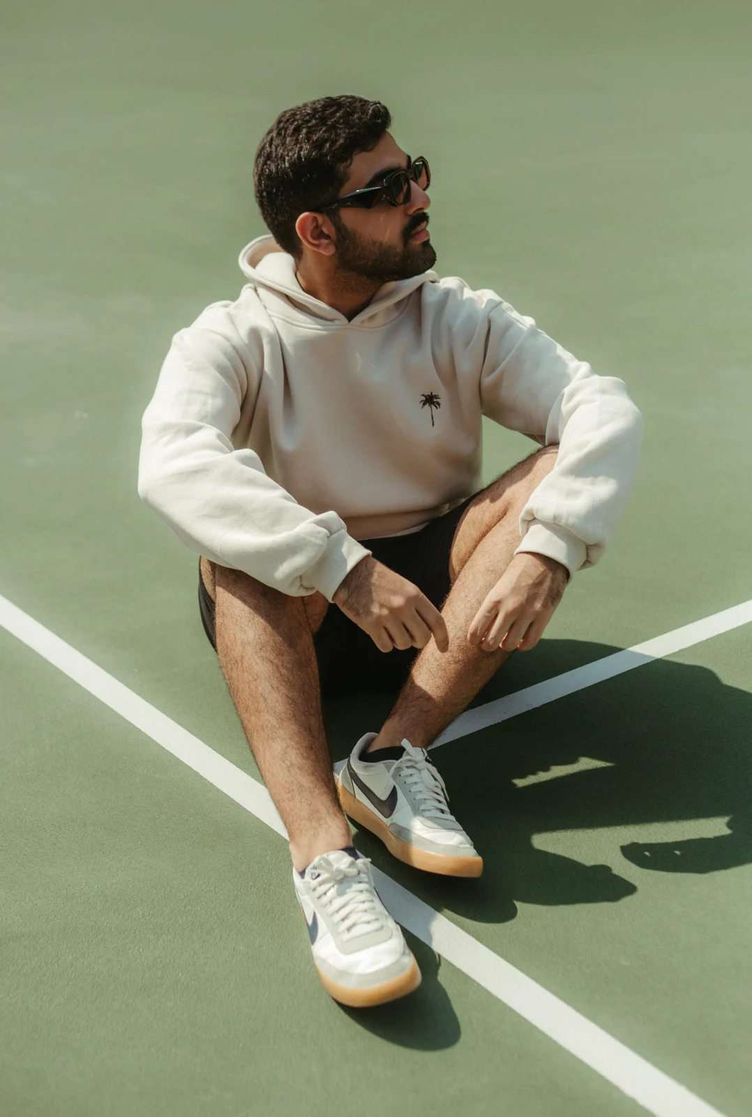Seated model in a white PALM’S outfit