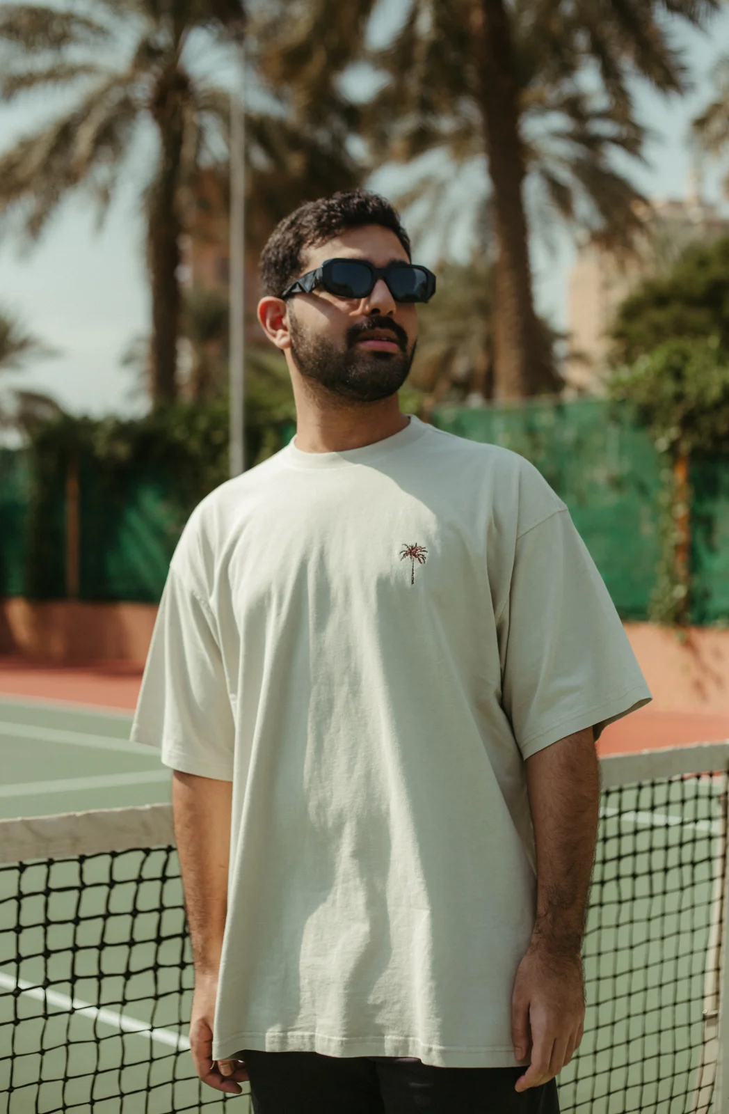 White PALM’S T shirt and cap on an outdoor court